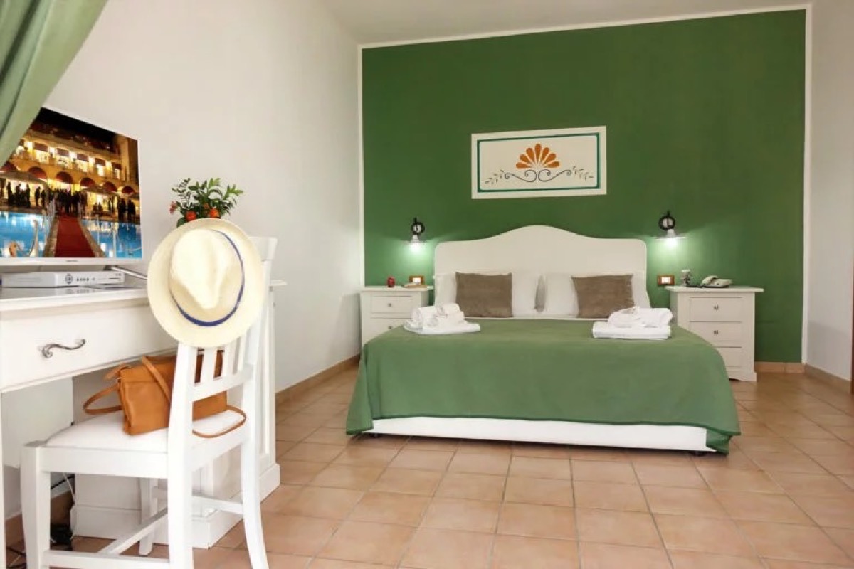 A bright double room at Mediterranea Hotel Leuca with a painted headboard